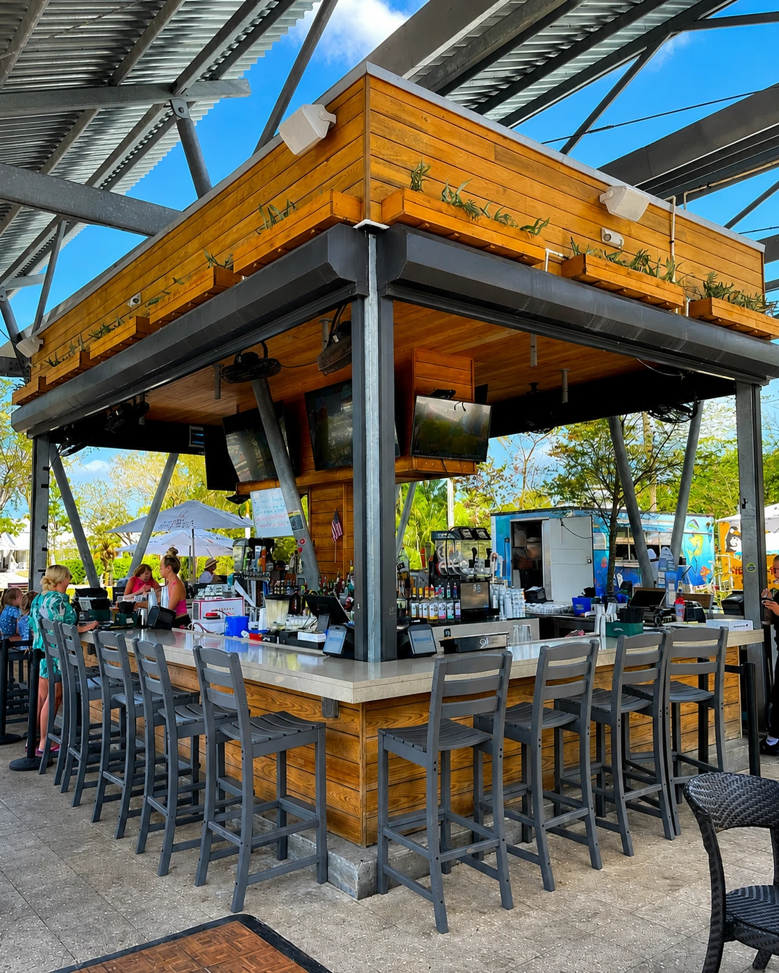 Waterfront bar at Celebration Park Naples with craft cocktails at sunset